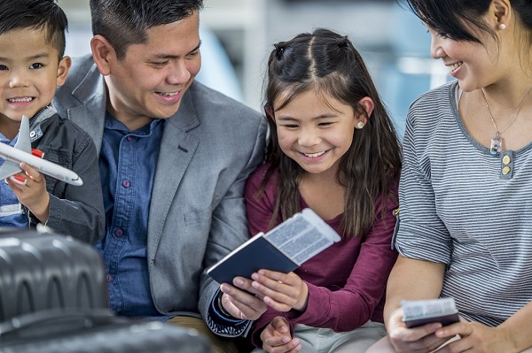 family at the airport holding passports and flight tickets